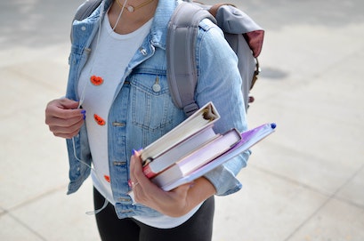 student with books in hand